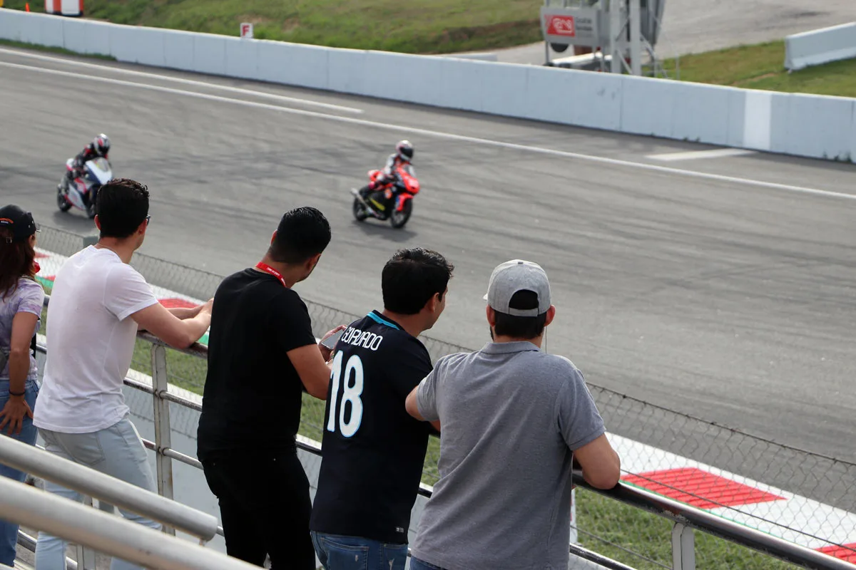 Johan Cruyff Institute students next to track with MotoGP training.